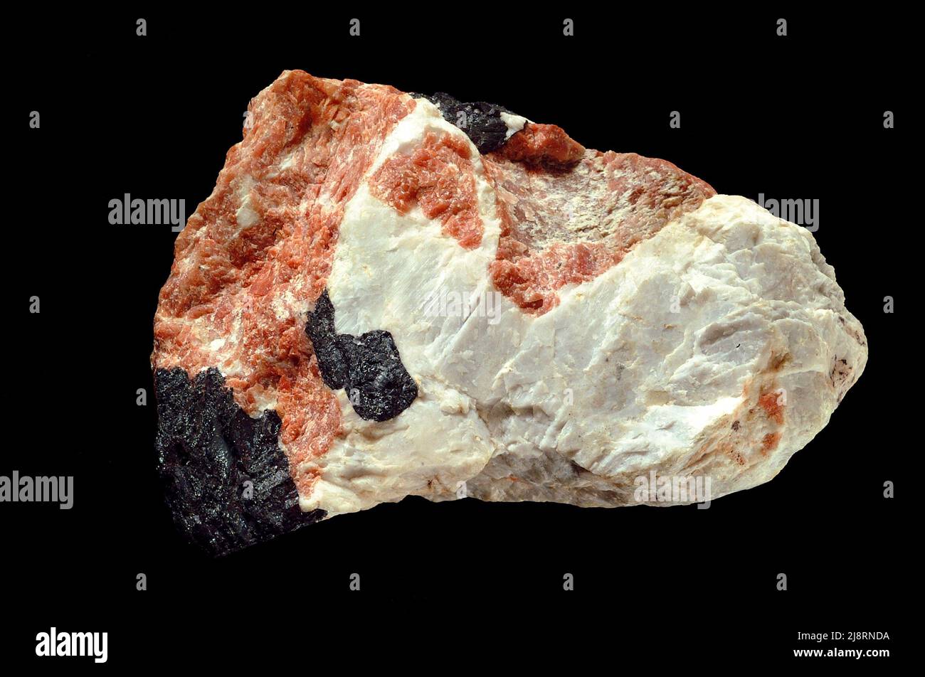 Troostite (willemite), calcite e franklinite da Franklin, New Jersey. Il minerale pinkish è trostite, una varietà ricca di manganese di willemite, ZnSi2O4. Il minerale bianco è la calcite, CaCO3. Il minerale nero è la franklinite, un minerale di spinello avente formula generale ZnFe204. Questo campione, proveniente dalla famosa località di raccolta di minerali a Franklin, New Jersey, si trova a 9 cm di distanza. Foto Stock