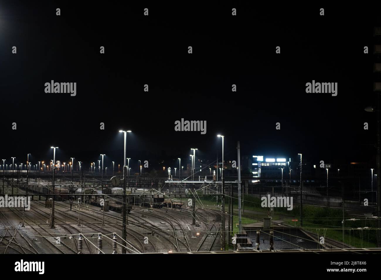 Stazione di trasporto di notte a Zurigo, Spreitenbach. I treni merci sono illuminati da luci di lettura luminose. Foto Stock