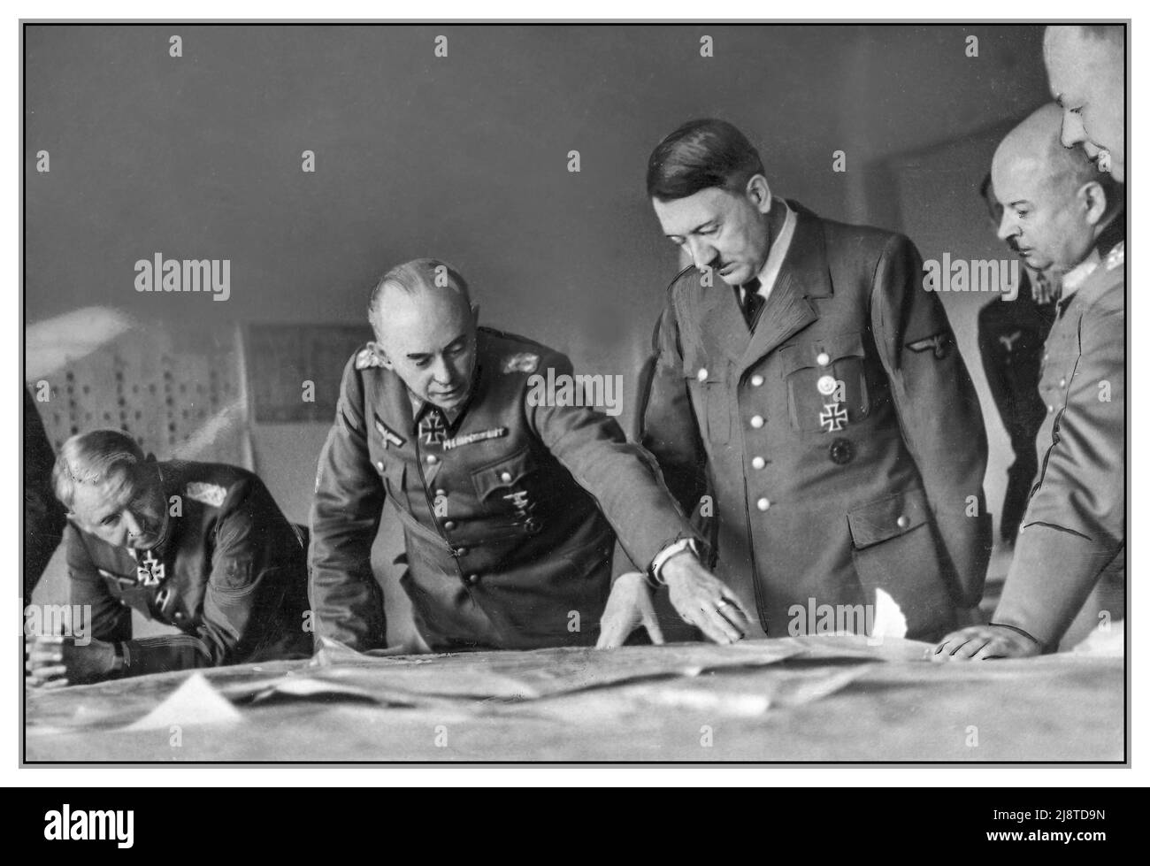 Pianificazione della battaglia di Adolf Hitler strategia di battaglia di Wolf Tabella 1940s con i suoi generali superiori compreso il maresciallo di campo Erich von Manstein della Wehrmacht Adolf Hitler con i generali Manstein, Kleist, Zeitzler & Ruoff in un briefing di strategia di battaglia con i piani e le mappe di guerra, 1943. Adolf Hitler viene informato sul fronte orientale. Da destra: Esercito generale Ewald von Kleist, generale Kurt Zeitzler, Adolf Hitler, generale Ruoff & Wermacht esercito generale Erich von Manstein., 1943 Wolfs Lair Prussia Foto Stock