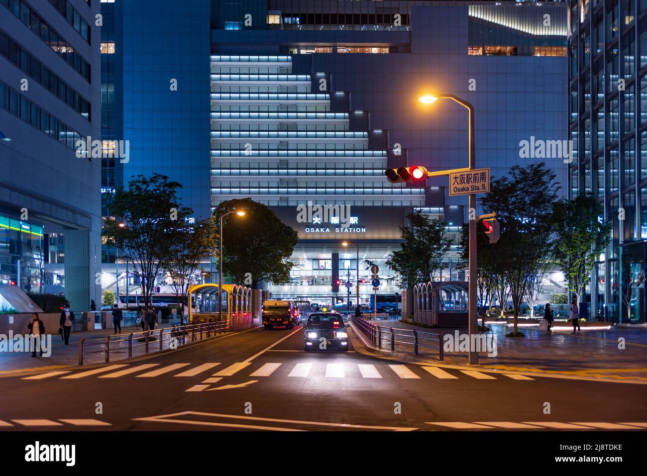 Osaka, Giappone - 1 maggio 2022: Il taxi attende al semaforo di fronte alla stazione JR di Osaka di notte Foto Stock