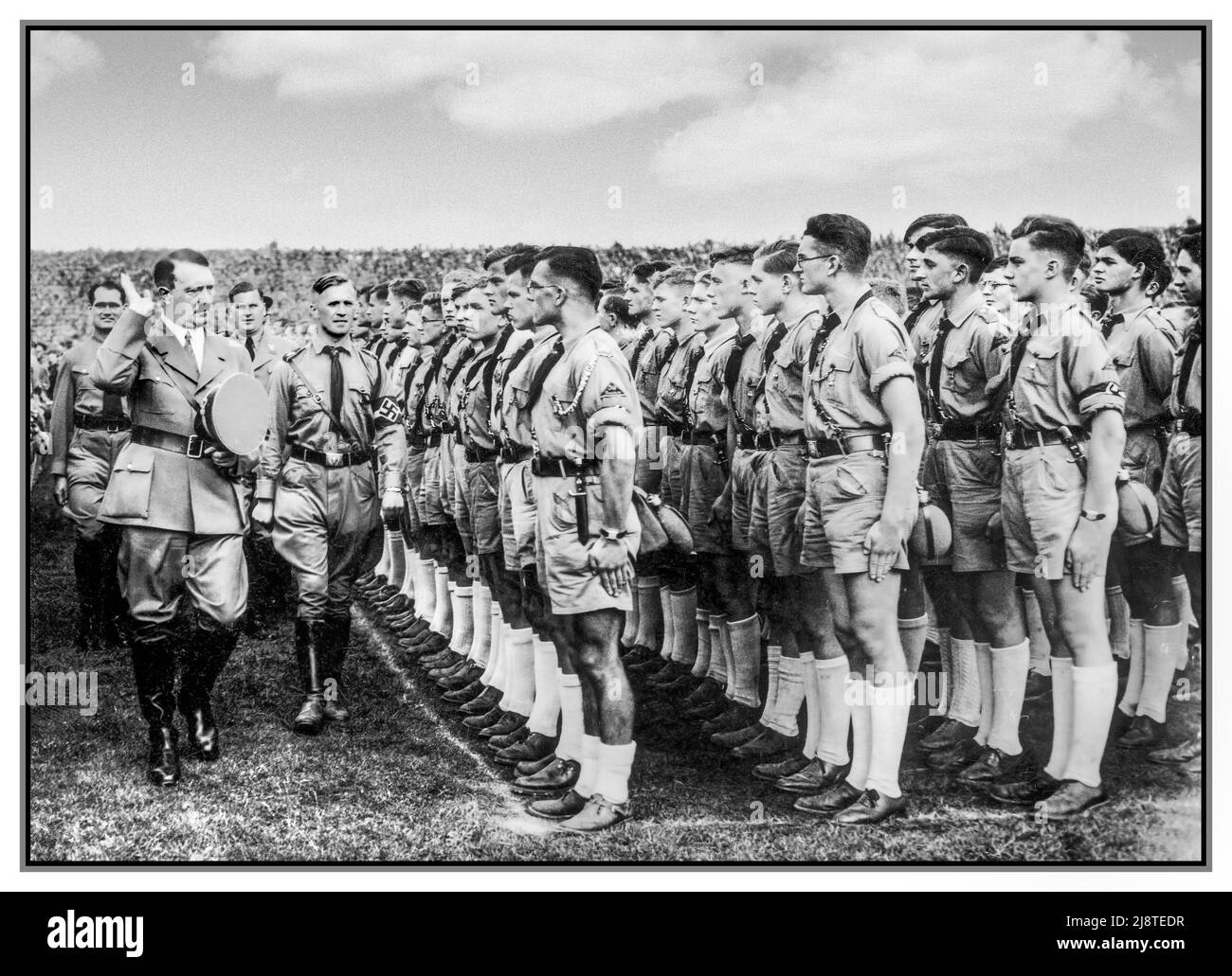 HITLER GIOVANE Adolf Hitler saluto una giovane gazzetta di Hitler (Hitlerjugend) di giovani uomini in uniforme (pantaloncini, magliette marroni, ecc.) durante il Rally di Norimberga 1935, il Congresso del Partito nazista (NSDAP) del 7th che si è tenuto a Norimberga (Nürnberg), 10–16 settembre. Hitler è accompagnato da Rudolf Hess, Baldur von Schirach, etc Germania nazista 1935 Reichsparteitag der NSDAP; Nürnberg, 10.–16. Settembre 1935; Rudolf Heß, Adolf Hitler, Baldur von Schirach, Hitlerjugend Foto Stock