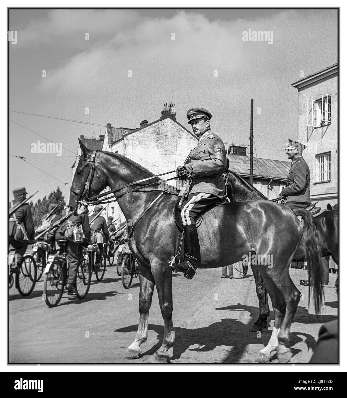 MANNERHEIM WW2 Comandante in capo, il maresciallo Carl Gustav Mannerheim sul suo cavallo di parata che esamina le truppe di parata alcuni in bicicletta a Viipuri, Finlandia 1939. Foto Stock