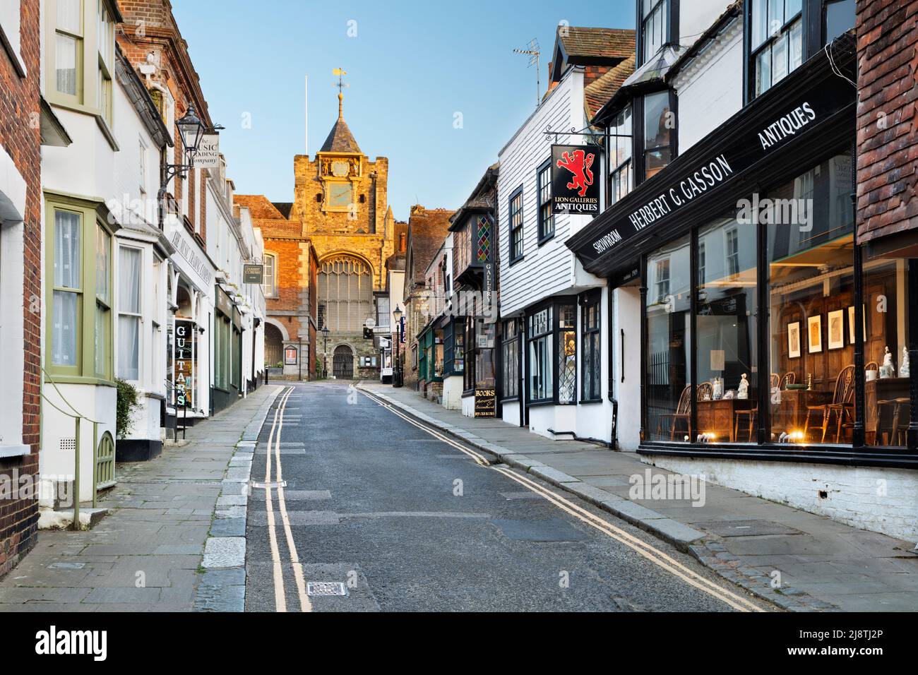 Negozi lungo Lion Street con la Chiesa di Santa Maria in luce del sole di sera, Rye, East Sussex, Inghilterra, Regno Unito, Europa Foto Stock