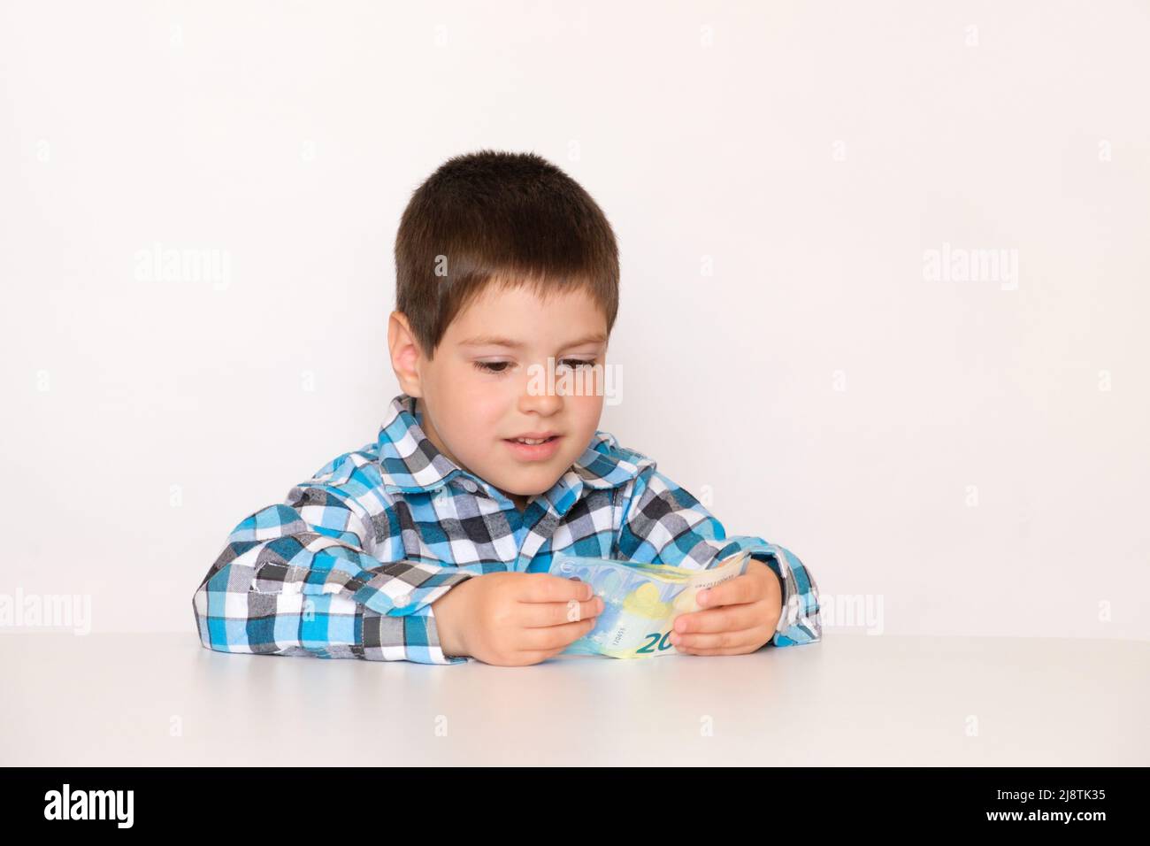Un ragazzo di 4 anni conta soldi, tiene euro nelle sue mani. Insegnare ai bambini l'alfabetizzazione finanziaria, soldi da tasca. Foto Stock