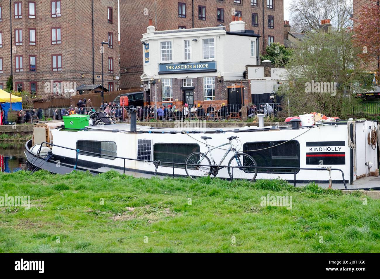 Vista del tradizionale Anchor e Hope inglese Fullers pub lungo il fiume e barche case galleggianti sul fiume Lea Clapton Londra E5 Inghilterra Regno Unito KATHY DEWITT Foto Stock
