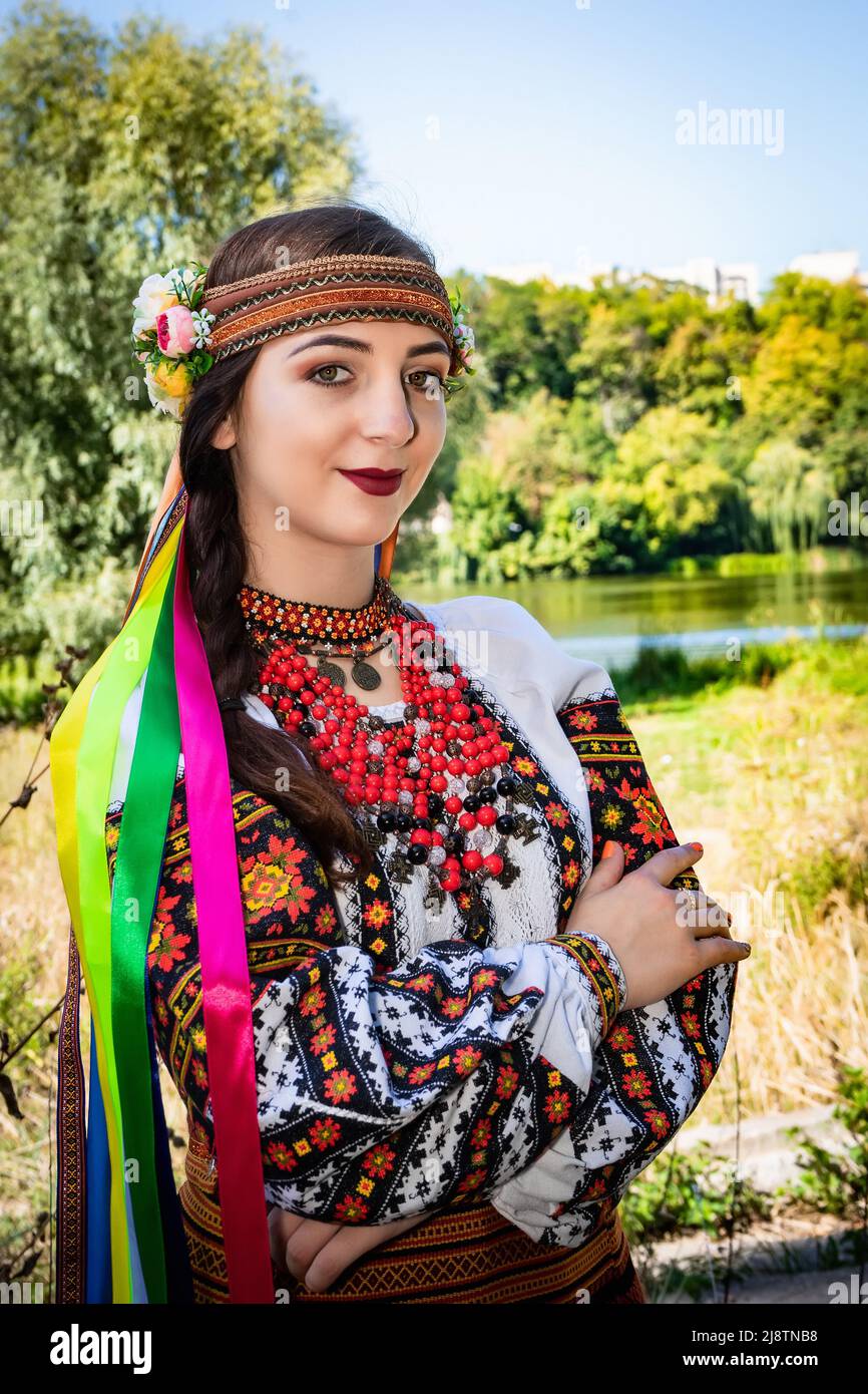 Una donna Ucraina in una camicia ricamata si erge sulla riva del fiume. Foto Stock