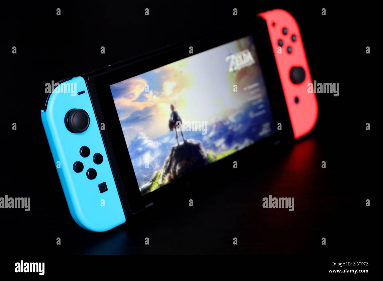 Nintendo Switch con il menu Legenda di Zelda su uno schermo, messa a fuoco selettiva. Console per videogiochi in modalità portatile con il Joy-con attaccato ai lati Foto Stock