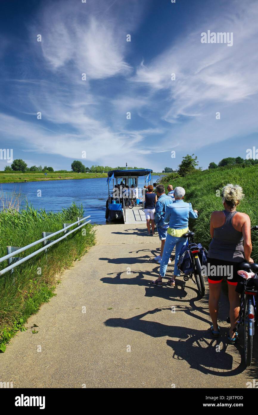 OHE en laak, Paesi Bassi - Luglio 9. 2021: Percorso con ciclisti in attesa per piccoli passeggeri in bicicletta traghetto sul fiume Maas fino alla città di confine belga di Opho Foto Stock