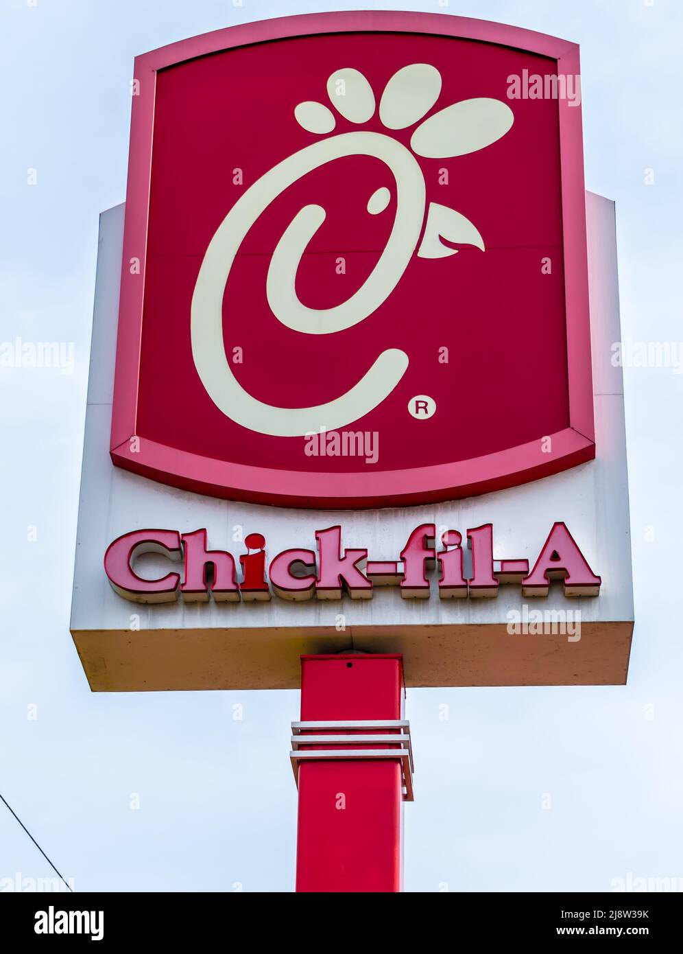 Outdoor Chick-fil-Un marchio indipendente e logo strada pubblicità in rosso e bianco in soft, luce del mattino presto nel sud di Charlotte, Carolina del Nord. Foto Stock