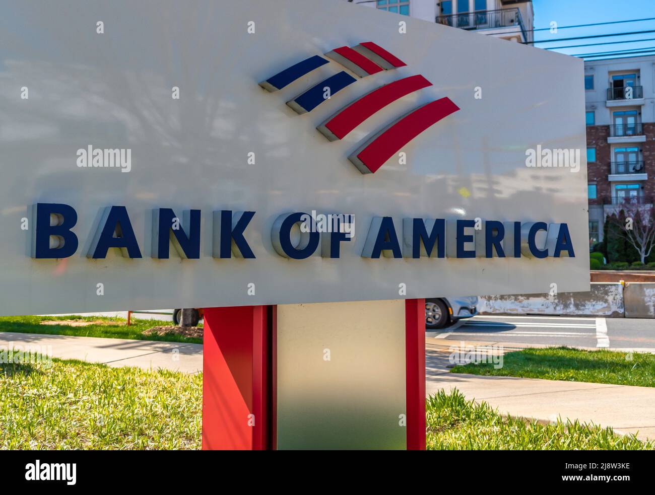 Outdoor, marchio e logo 'Bank of America' in piedi in rosso, bianco e blu con verde e riflessi in una giornata di sole. Foto Stock
