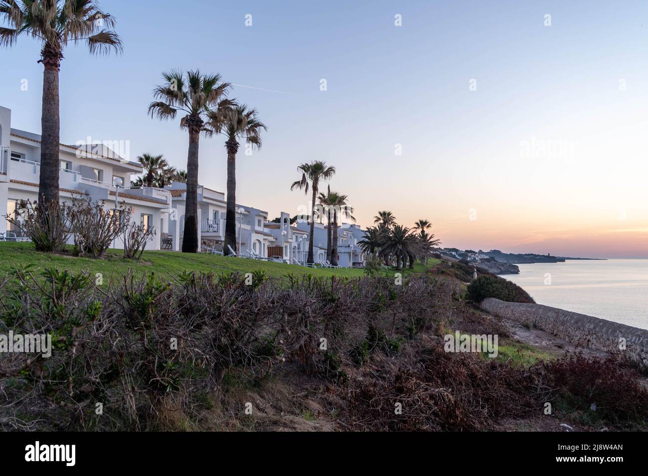 alba sulla spiaggia, case sulla linea costiera di maiorca, spagna Foto Stock