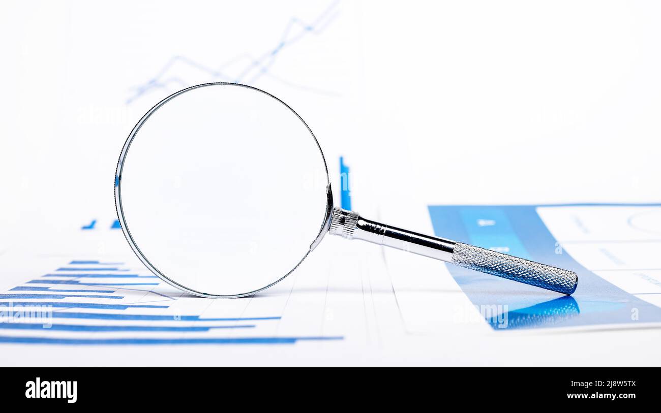 Grafici, grafici e lente di ingrandimento. Analisi della crescita aziendale o del rallentamento. Studio degli indicatori di prestazioni. Controllo della relazione finanziaria. Foto di alta qualità Foto Stock