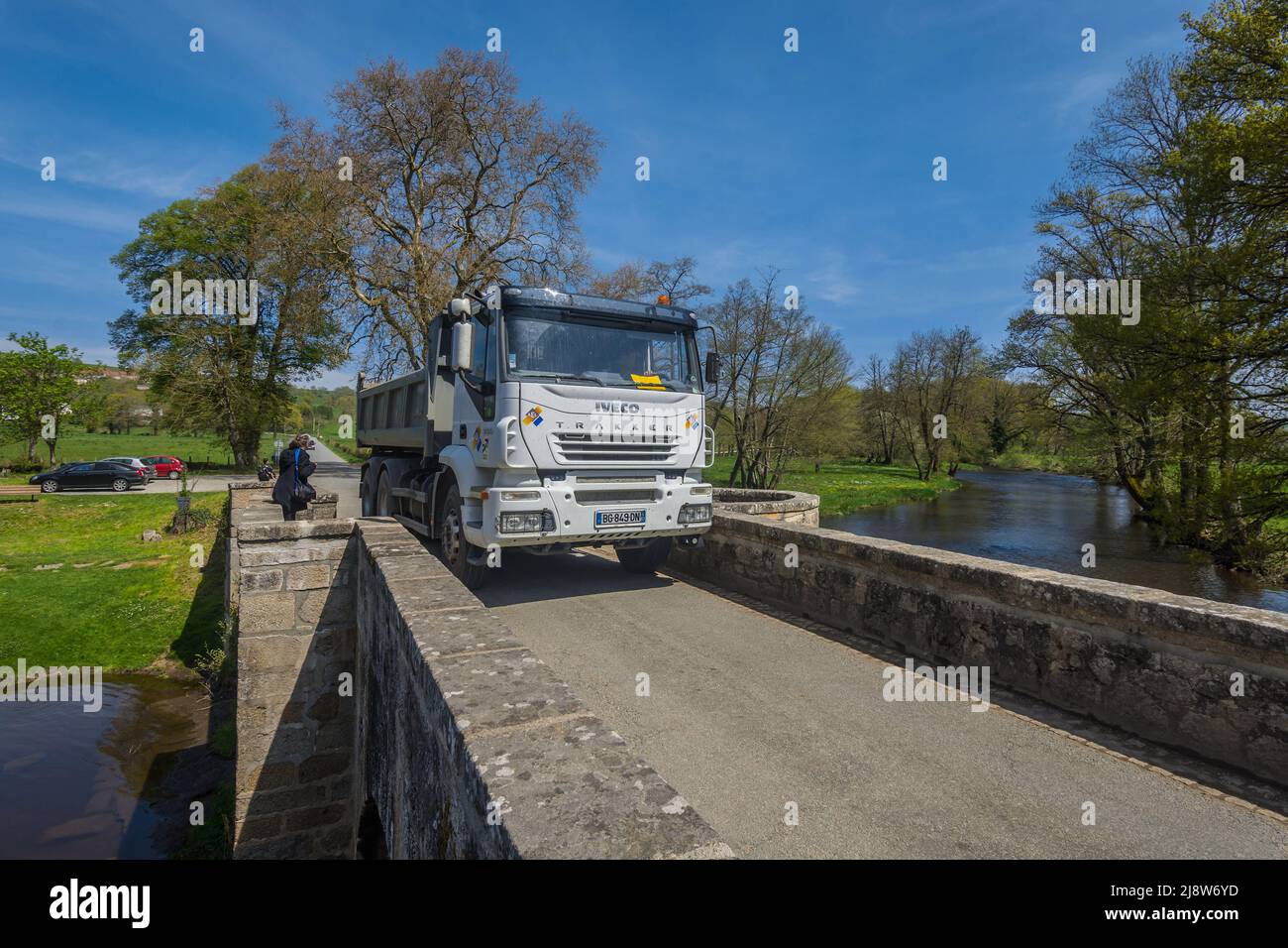 Autocarro pesante che attraversa lo stretto ponte romano costruito in pietra, attraverso il fiume Creuse a Moutier d'Ahun, Creuse (23), Francia. Foto Stock