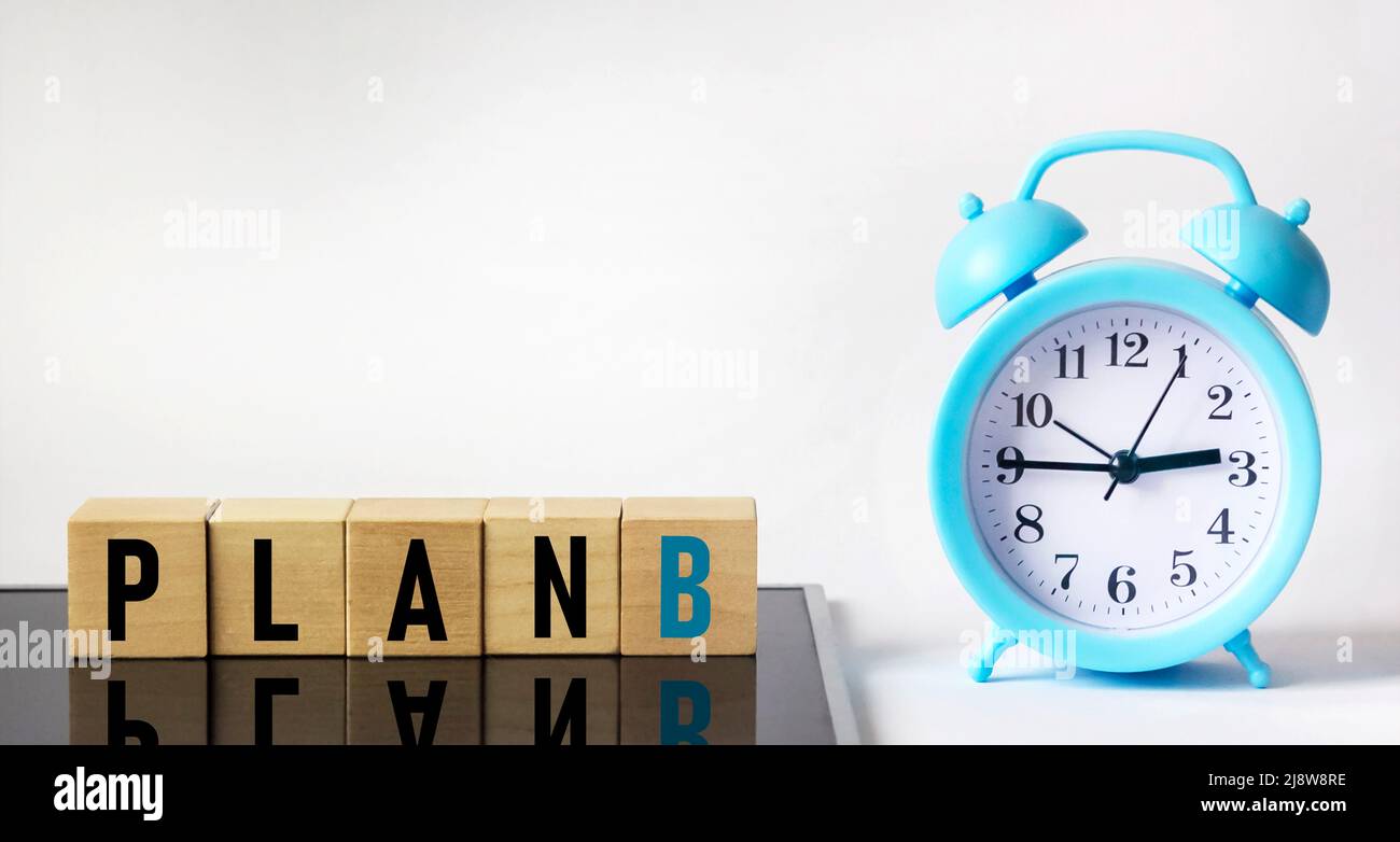 Cubo di legno con la parola PIANO B su sfondo bianco e nero con un orologio. Business concept Foto Stock