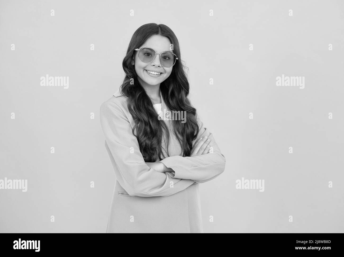 bella ragazza felice teen con capelli ricci in elegante giacca viola e occhiali da sole, modello di moda. Foto Stock