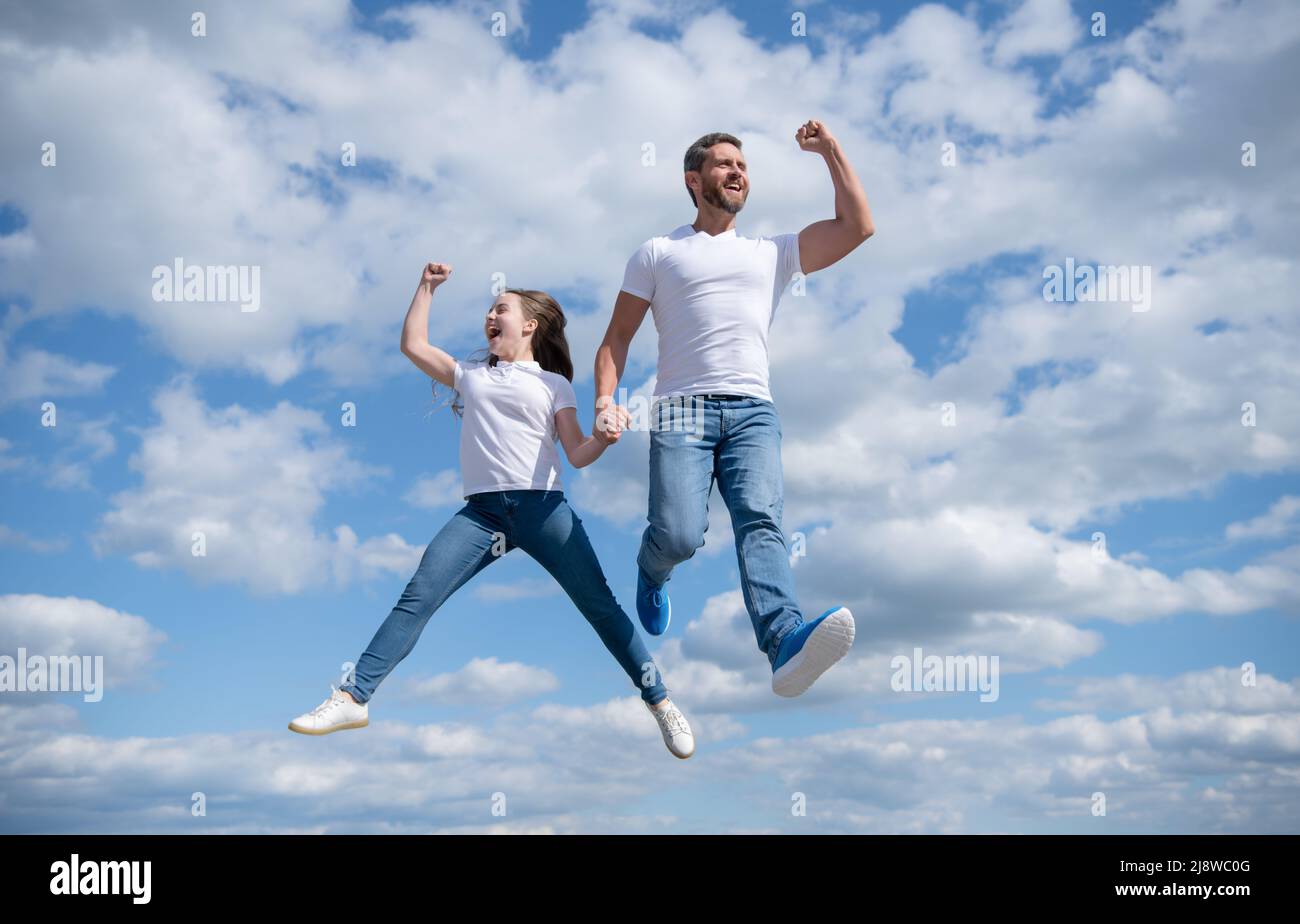 felice padre e figlia saltano nel cielo. immaginazione Foto Stock