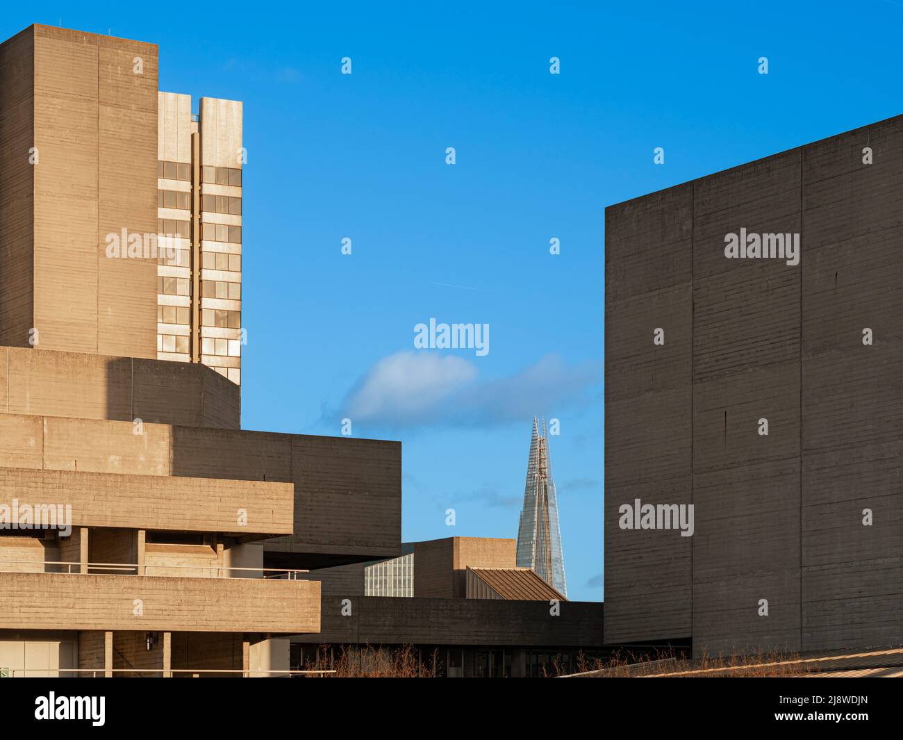 La facciata brutalista del Teatro Nazionale di Londra con l'architettura neofonuristica dello Shard in lontananza. Londra. Foto Stock