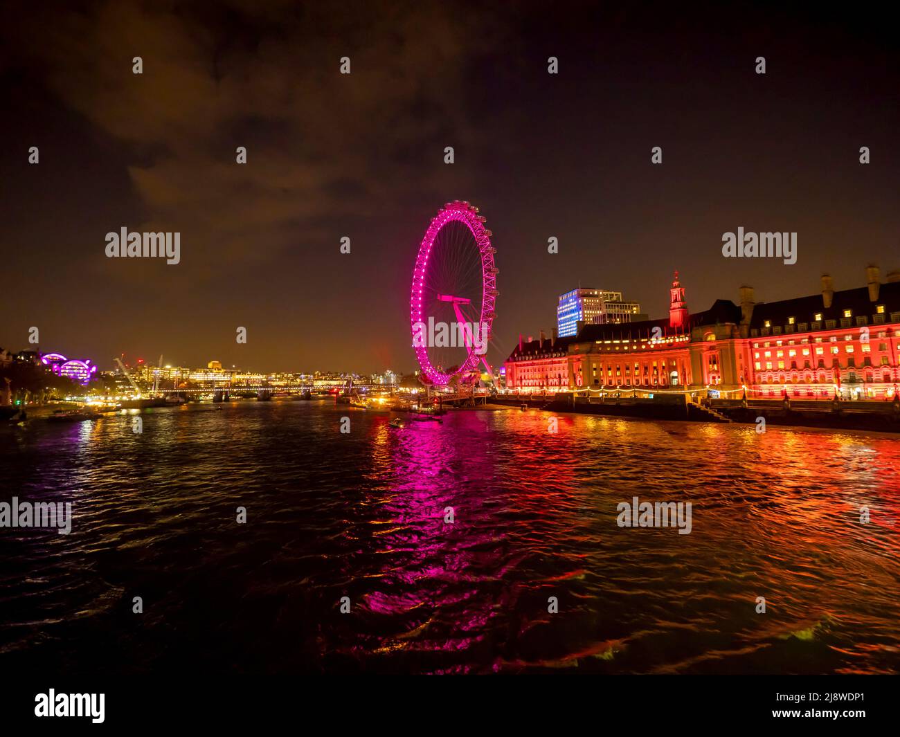 Il London Eye di notte, illuminato da luce rosa, si trova lungo la Queen's Walk. Londra. Foto Stock