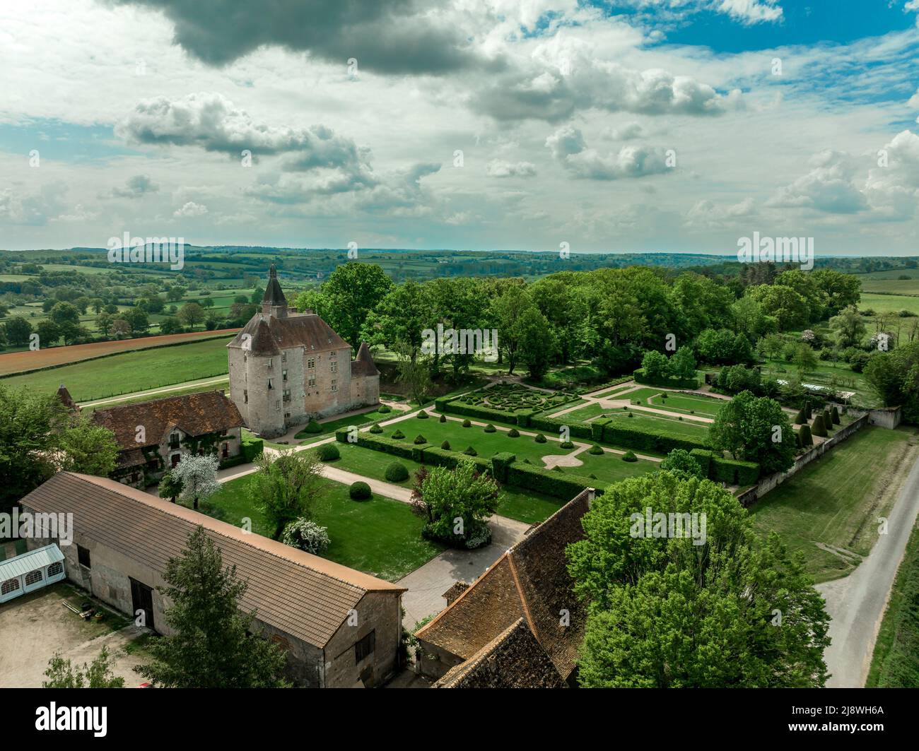 Veduta aerea del castello medievale francese di Beauvoir restaurato con ponte, torri, prato curato e giardino Foto Stock