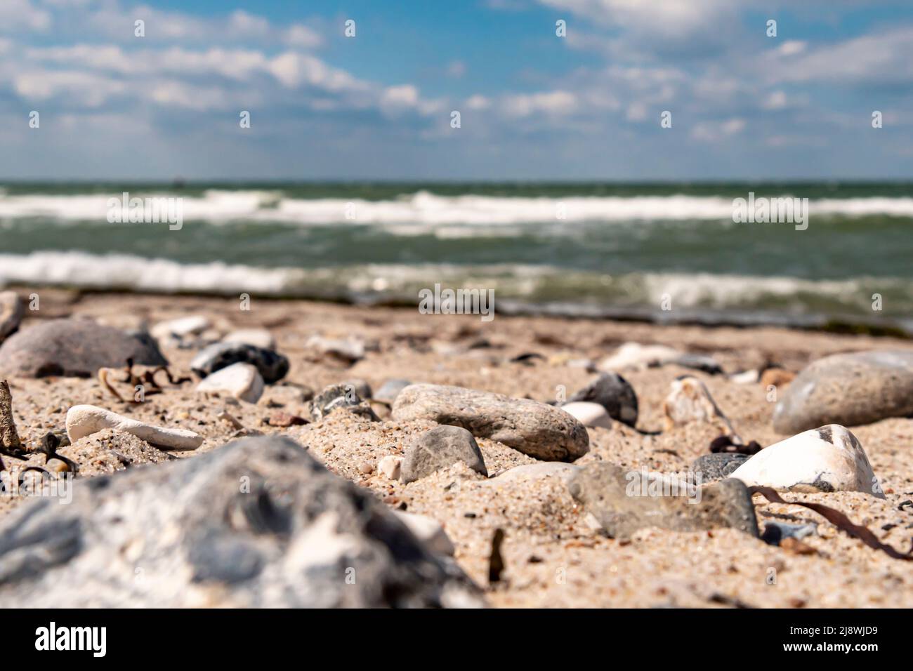 Scatto al piano terra di una spiaggia di sabbia che si affaccia sul mare. Bassa profondità di danno Foto Stock