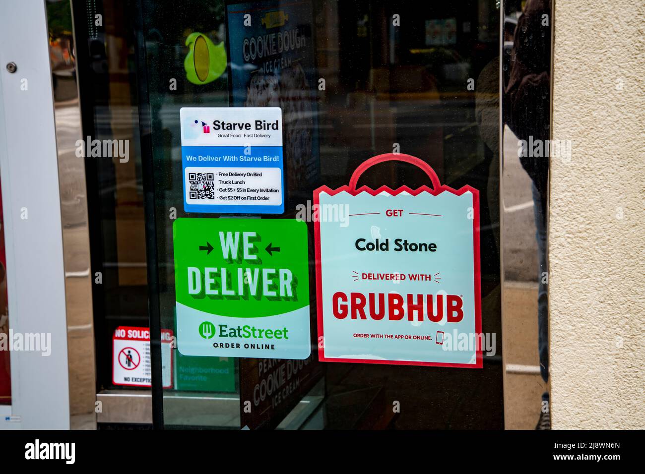Lawrence, Kansas. Varietà di servizi di consegna di cibo pubblicizzati nella vetrina del negozio di ristoranti. Foto Stock