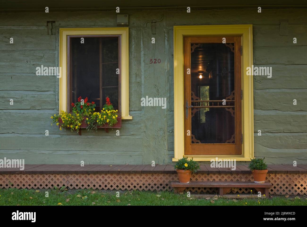 Vecchio circa 1840 Canadiana cottage stile verde oliva dipinto di case in tronchi facciata con finiture gialle. Foto Stock