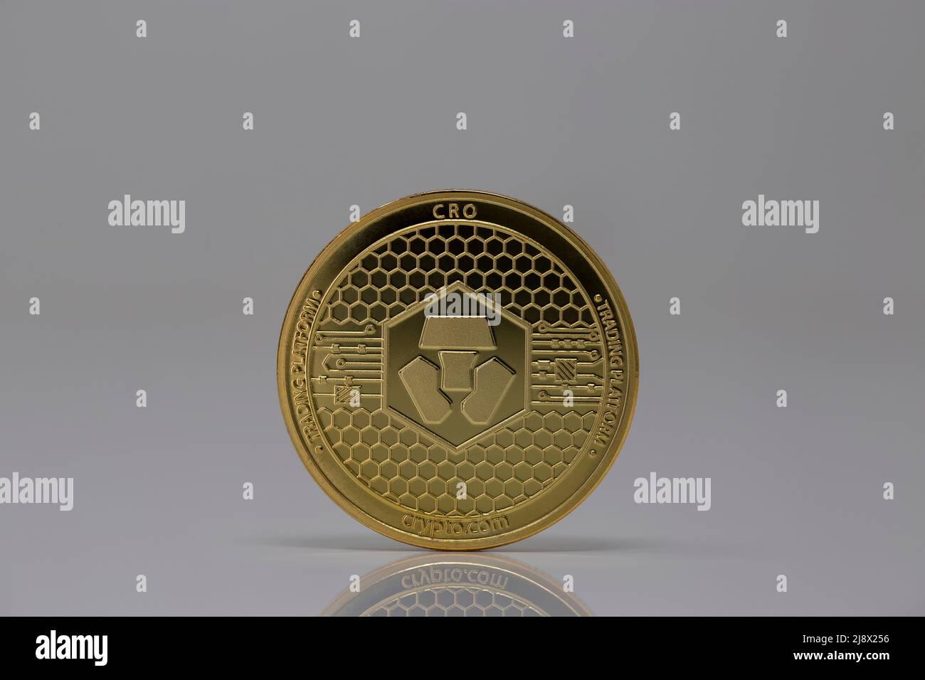 CRONO CRO Cryptocurrency Physical Coin posizionato sulla superficie riflettente nello sfondo chiaro. Foto Stock