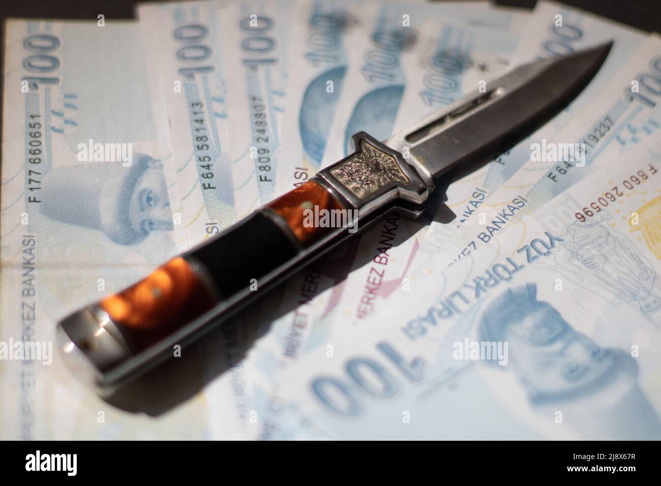 Un coltello e banconote Foto Stock