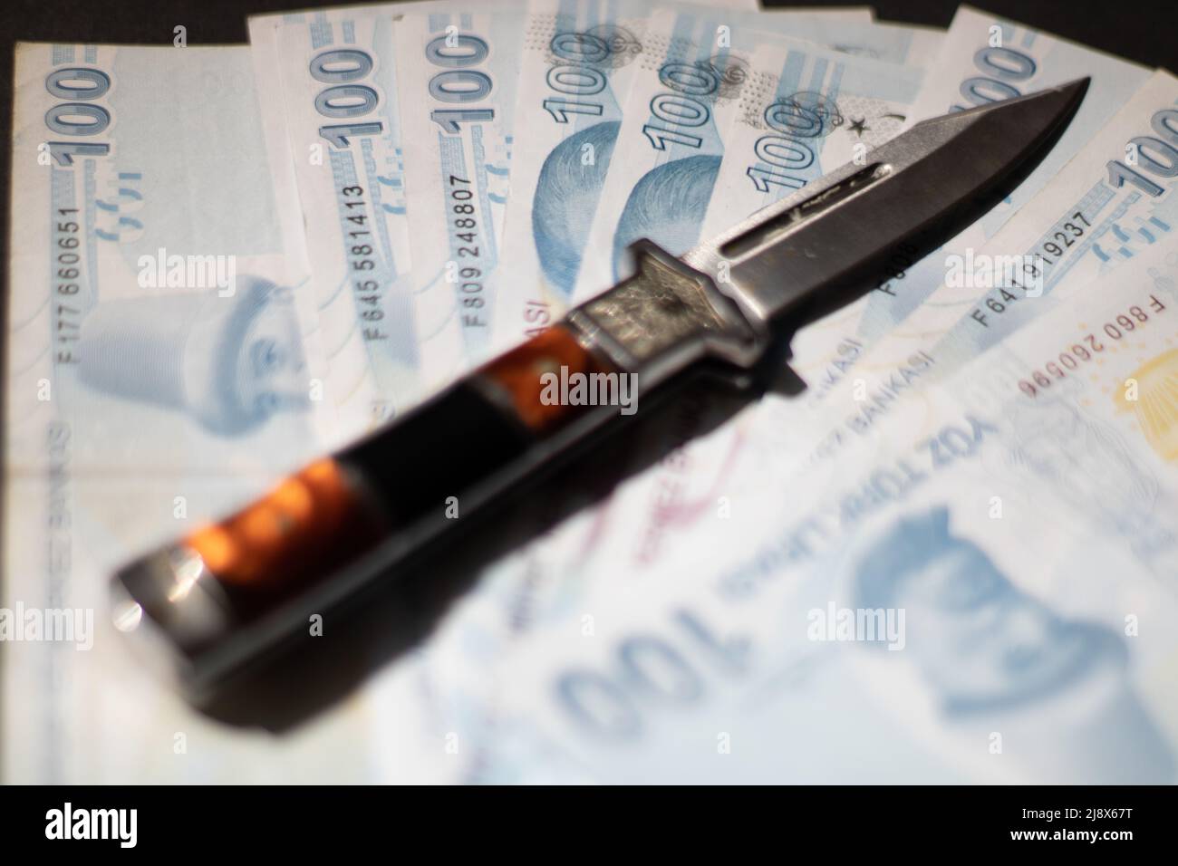 Un coltello e banconote Foto Stock