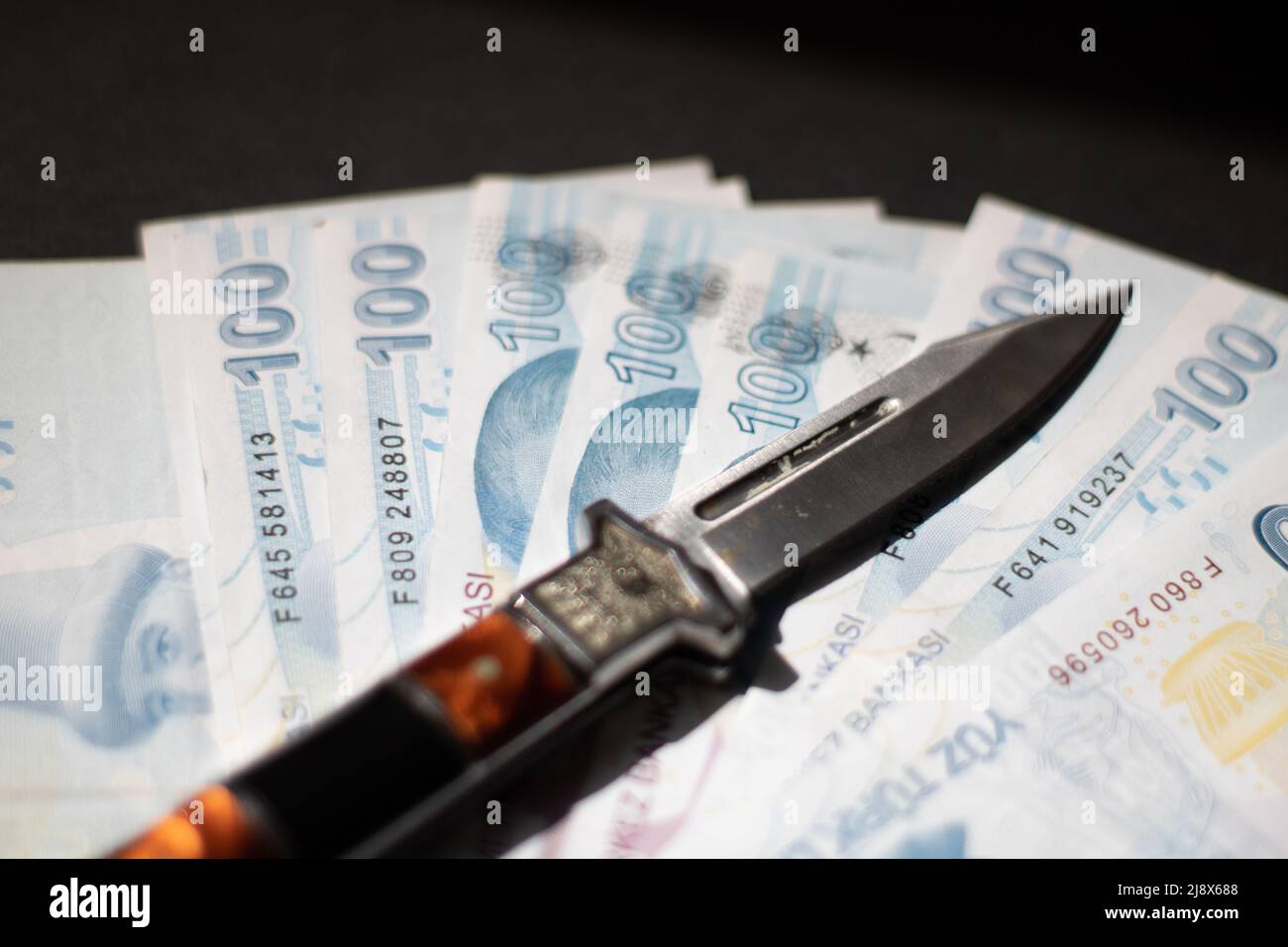 Un coltello e banconote Foto Stock