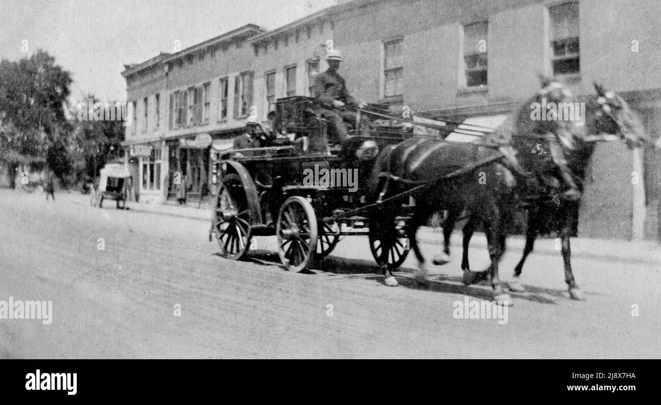 Carrozza di fuoco trainata da cavalli a Belleville, Ontario, con S.H. Barnum, vigile del fuoco e pilota, con il capo Lynch sul retro della carrozza ca. 1910 Foto Stock