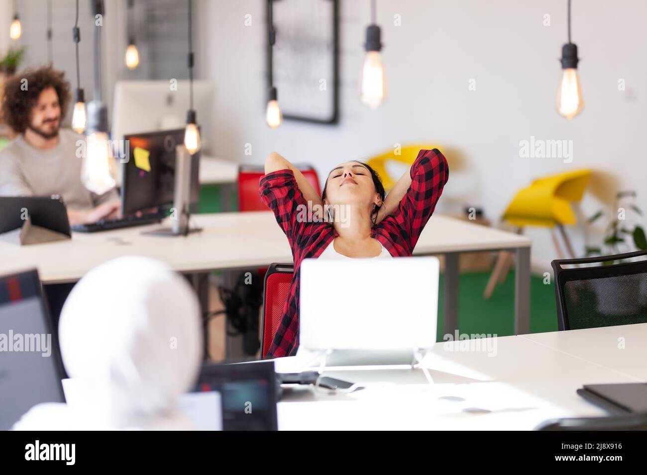 Team creativo di giovani che lavorano su computer desktop in un moderno ufficio. Foto Stock