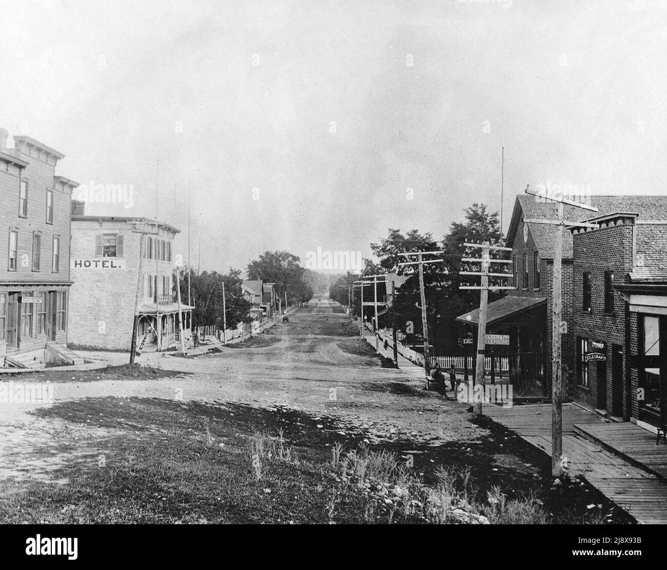 Marmora, Ontario, scena di strada. Hotel sul lato sinistro della fotografia. L'edificio in mattoni sulla destra ospitava il telegrafo e l'ufficio del telefono, mentre l'edificio a cornice sull'estrema sinistra (in primo piano) ospitava il salotto del biliardo ca. 1890 Foto Stock