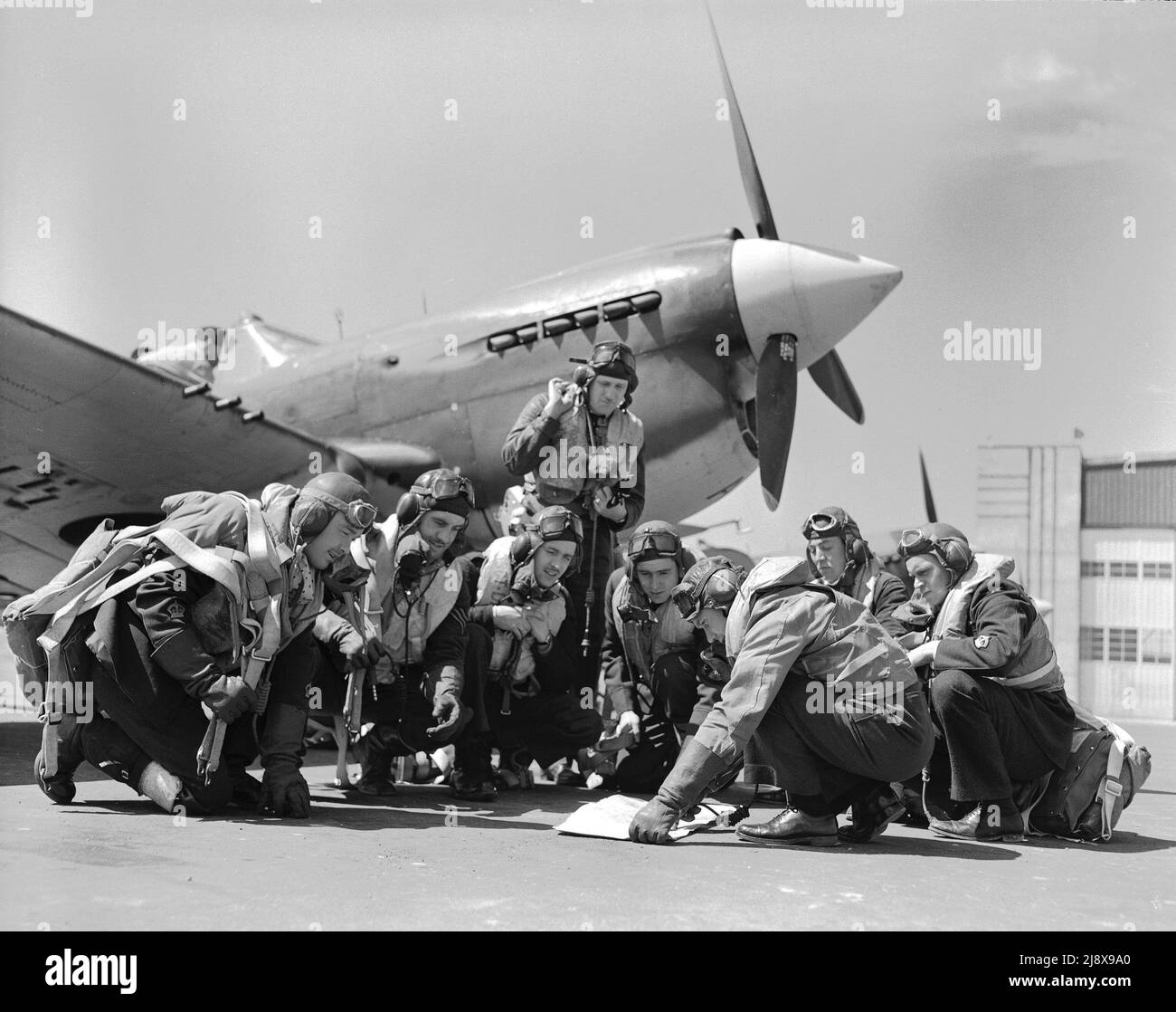 118 Sqn (RCAF) piloti Dartmouth, N.S. 1942 pianificazione del volo di fronte a uno squadrone Kittyhawk prima della partenza per la costa del Pacifico. Da sinistra a destra sono: Beirnes, Bourbonnais, Davidge, Roberts, Studholme, Moran, Pennock, Hindmarsh ca. 1942 Foto Stock
