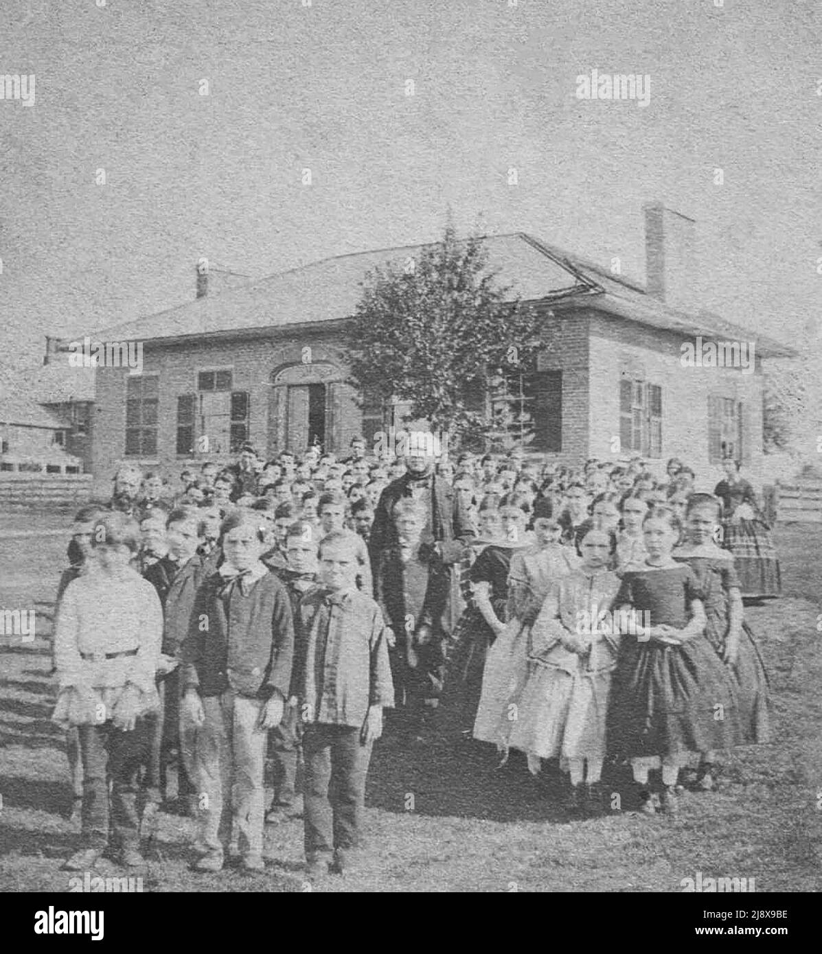 1850s Fotografia stereoscopica del personale e degli studenti al di fuori della Belleville Grammar School, Belleville, Ontario. Il principale era Alexander Burdon (al centro), e l'assistancato era William Tilley (a sinistra). La scuola è stata costruita nel 1851. Ca. 1857 Foto Stock
