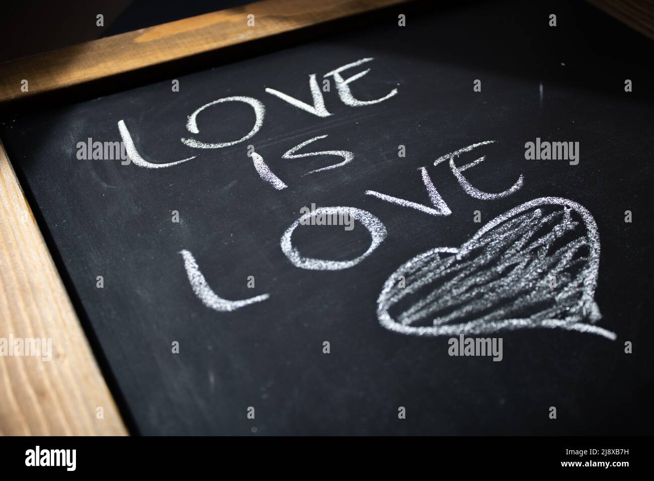 L'amore è amore e cuore su una lavagna Foto Stock