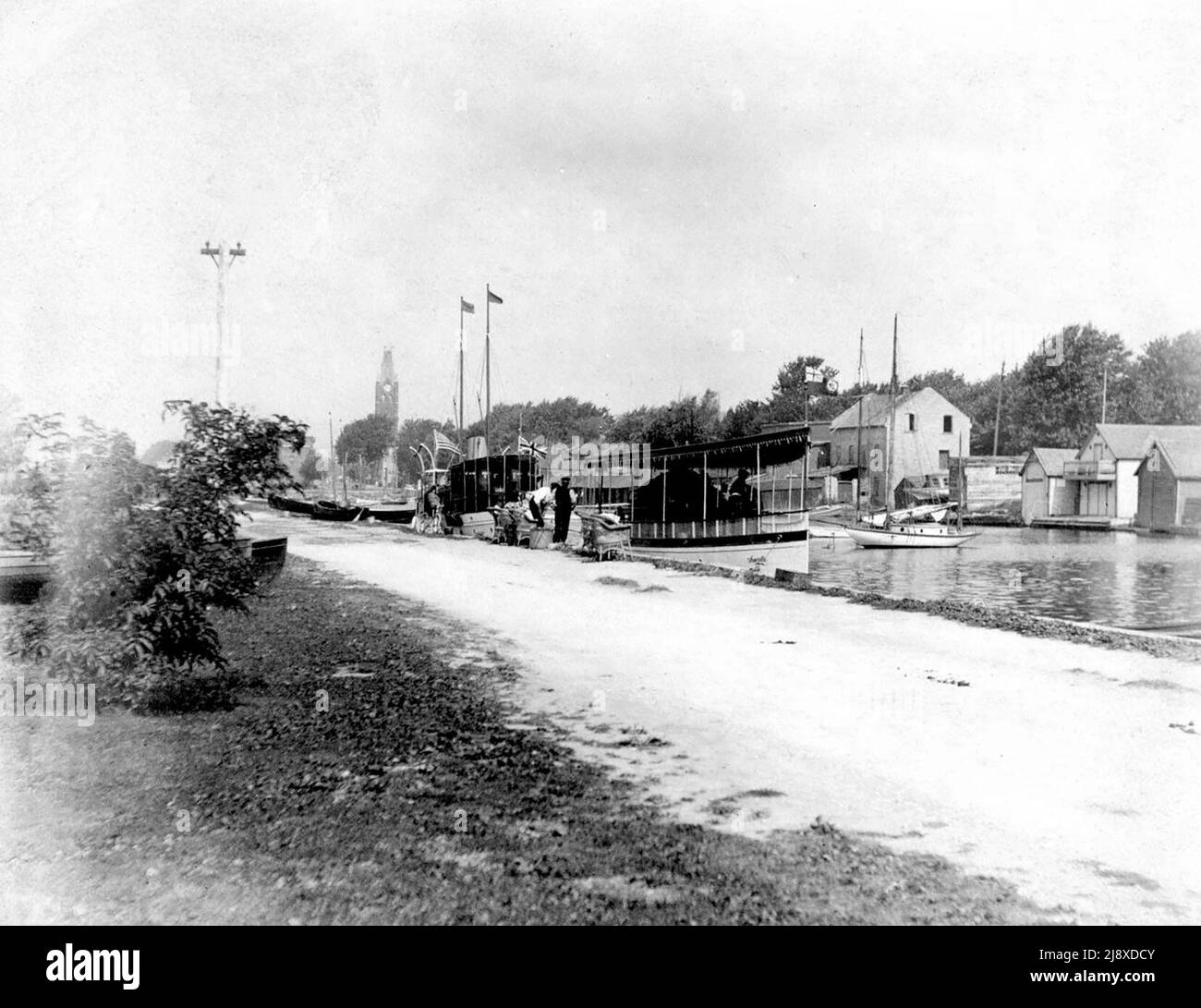 Il porto di Belleville, Ontario, da Victoria Park con City Hall in lontananza e barche con bandiere americane e britanniche ca. 1900 Foto Stock
