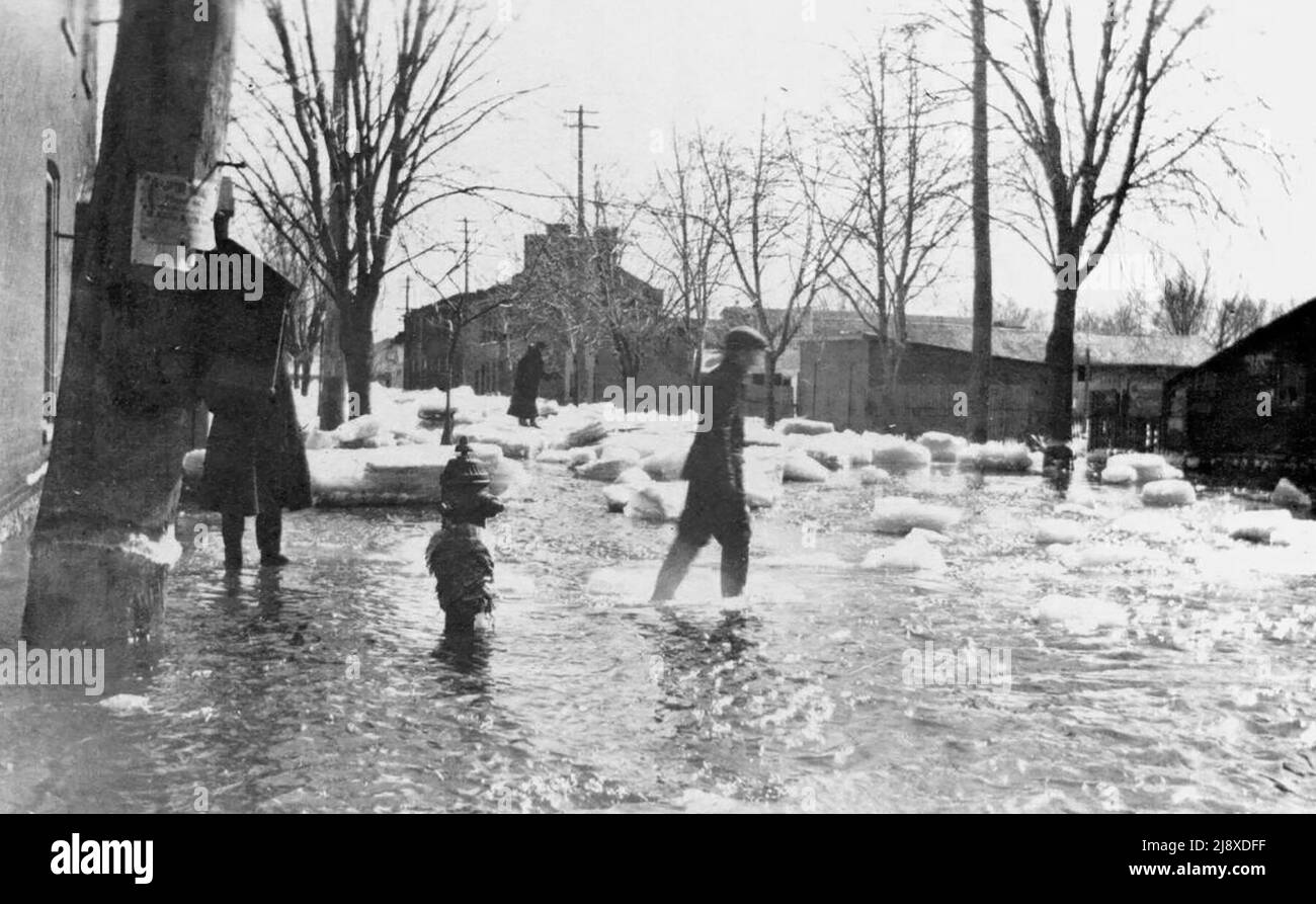 Marzo 1918 alluvione - strada allagata a Belleville, Ontario, con blocchi di ghiaccio e persone a piedi Foto Stock