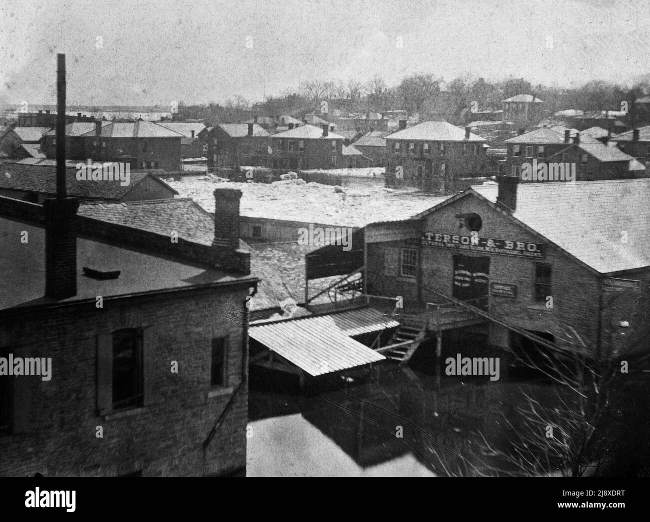 1886 alluvione sul fiume Moira a Belleville, Ontario - Paterson & Bro., Agricultural Implements Ware Room, W H Vantassel Agent, situato sul lato sud-est dell'entrata al ponte piedi ca. 1886 Foto Stock