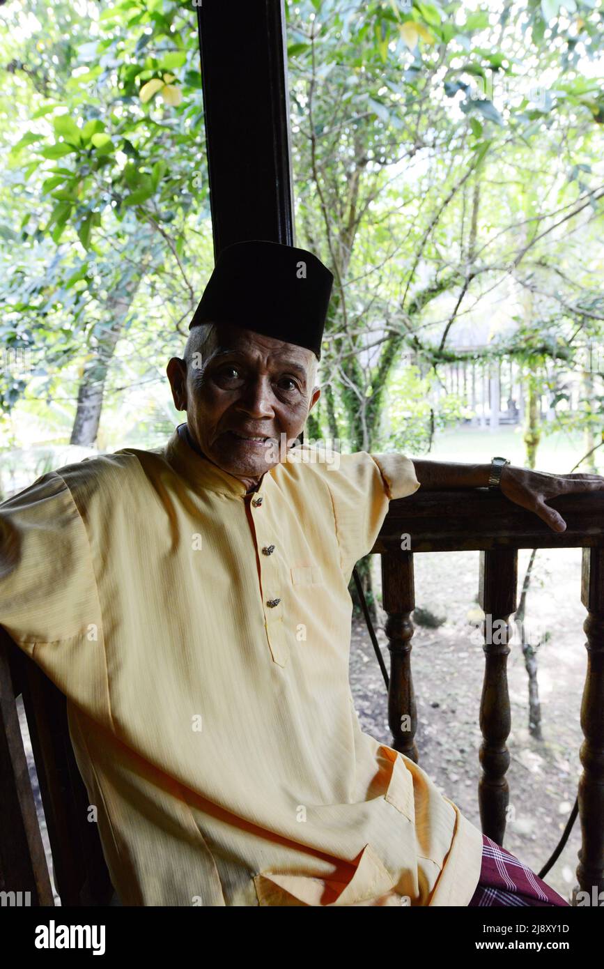 Un uomo malese che indossa un cappello tradizionale. Foto Stock