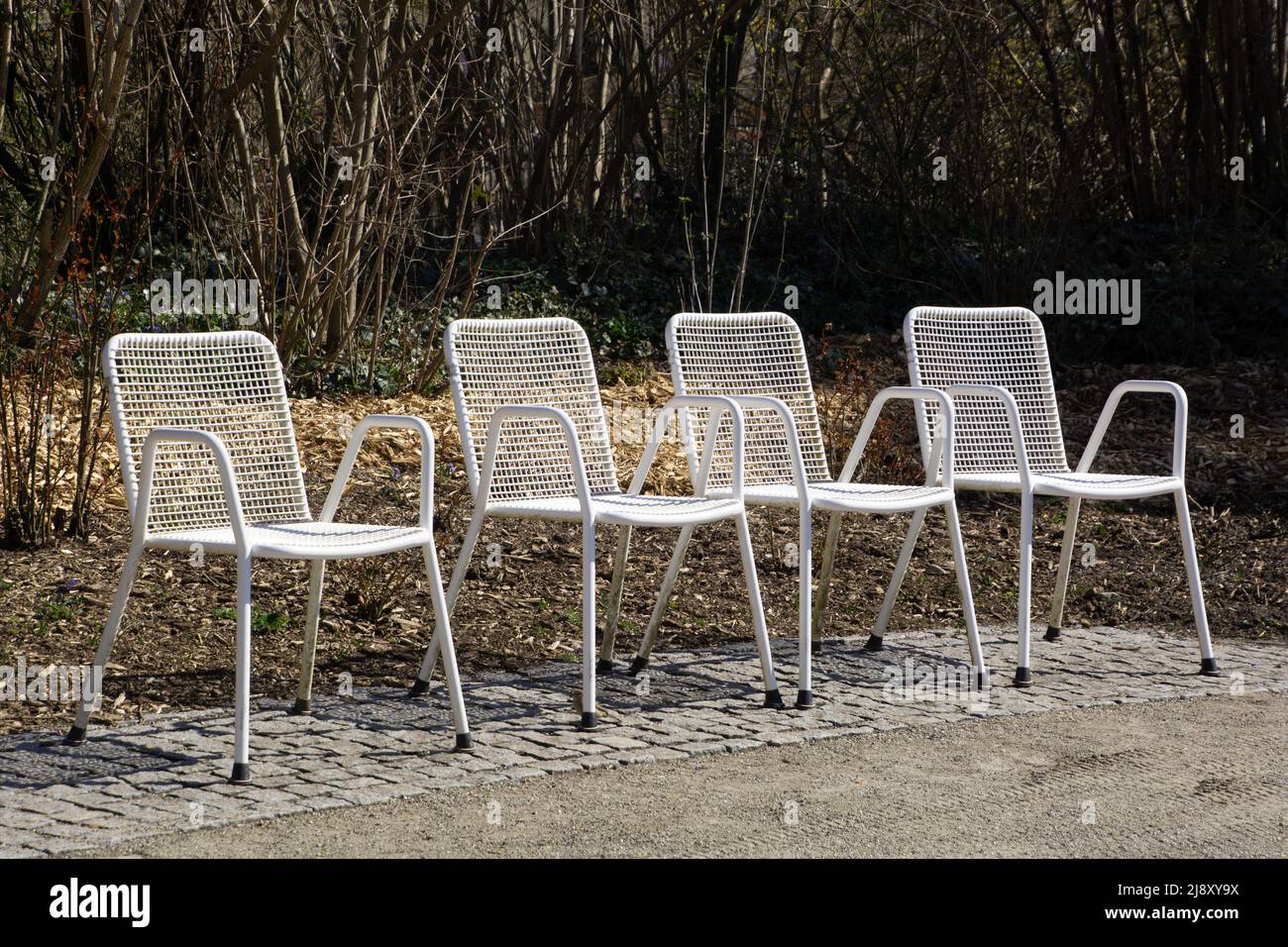 sedie a griglia bianche vuote in linea nella zona giardino in primavera Foto Stock