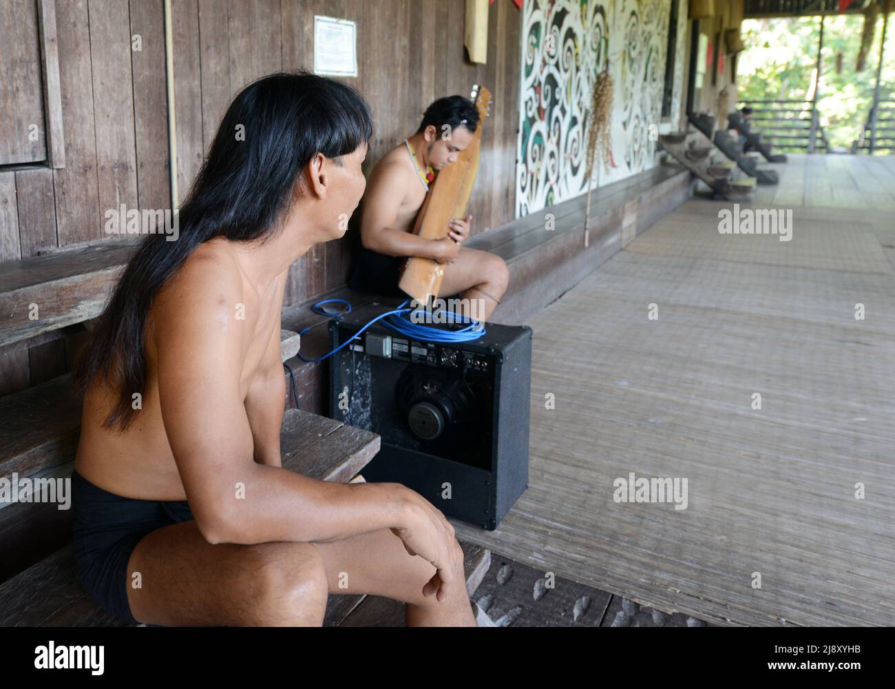 Un uomo tribale di Orang Ulu che suona il tradizionale Sape, un tradizionale strumento a corda del Borneo. Foto Stock