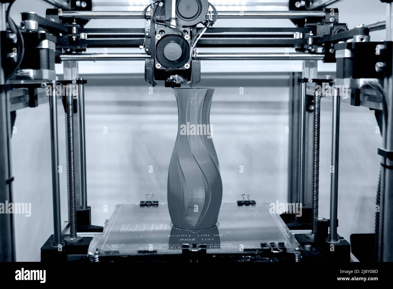 Elaborare il modello di stampa sulla stampante 3D. Computer con stampante digitale ad alta tecnologia in azione. Meccanismo di stampa aggiunta di livelli all'oggetto. Stampante FDM 3D che lavora nel laboratorio di stampa 3D. 3D tecnologia moderna. Foto Stock
