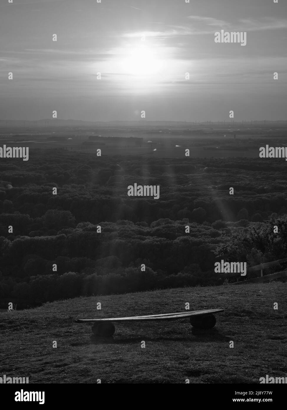 Vista del tramonto bianco e nero con panca in legno sulla collina di Braunsberg che si affaccia sulla campagna austriaca. Foto Stock