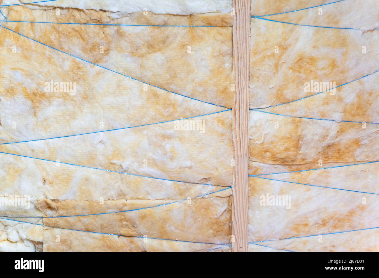 Il tetto è isolato con lana di vetro gialla. Bordatura isolante con filettatura, primo piano Foto Stock