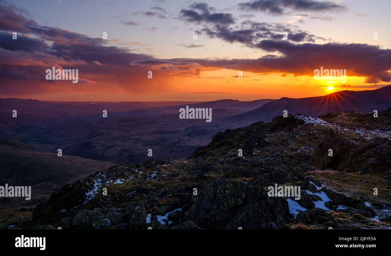Il sole tramonta su un lato leggero (Scafell range) nel Lake District inglese, Regno Unito Foto Stock