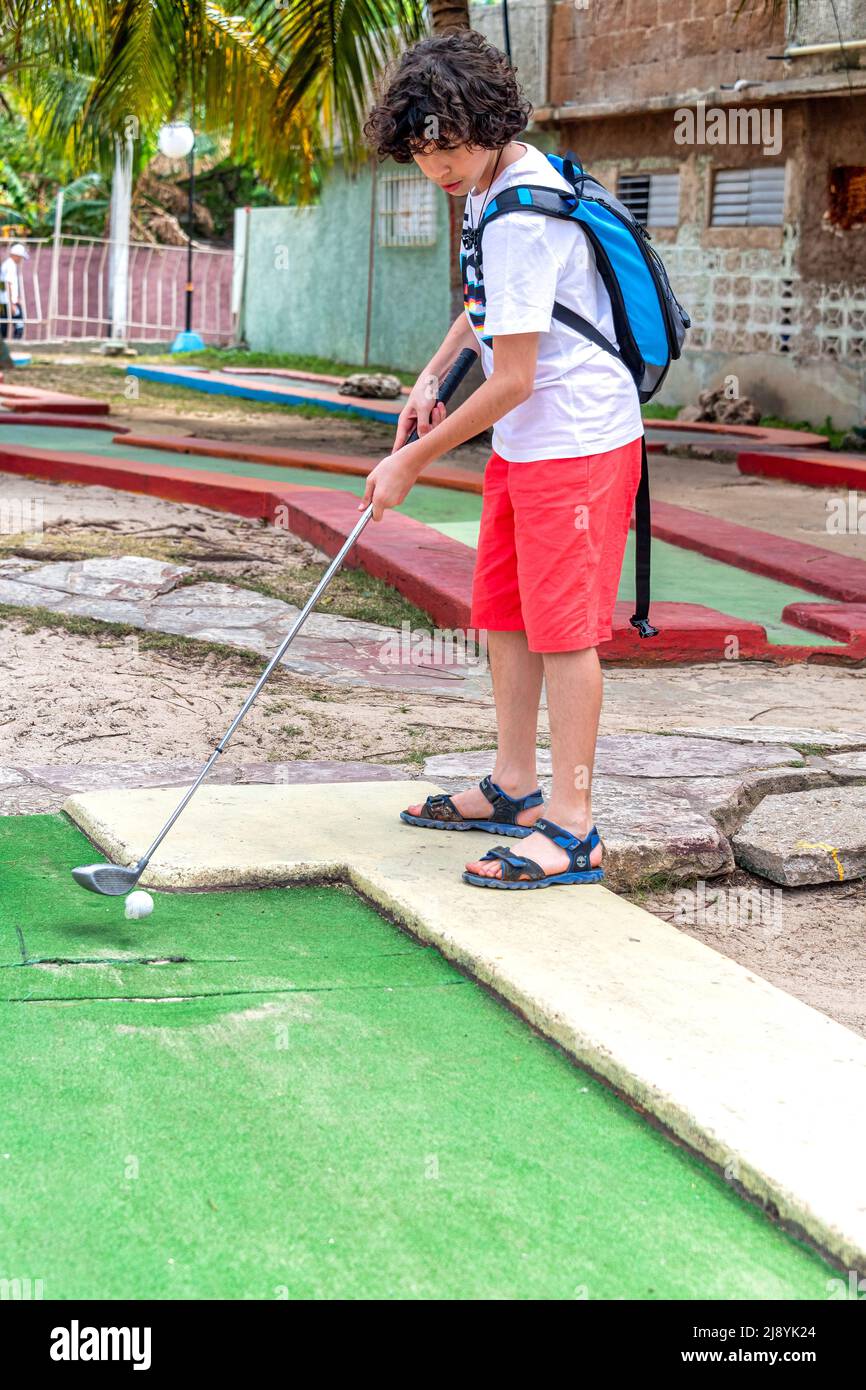 Un bambino cubano-canadese che gioca a El Golfito (mini-golf e snack bar), Varadero, Cuba Foto Stock
