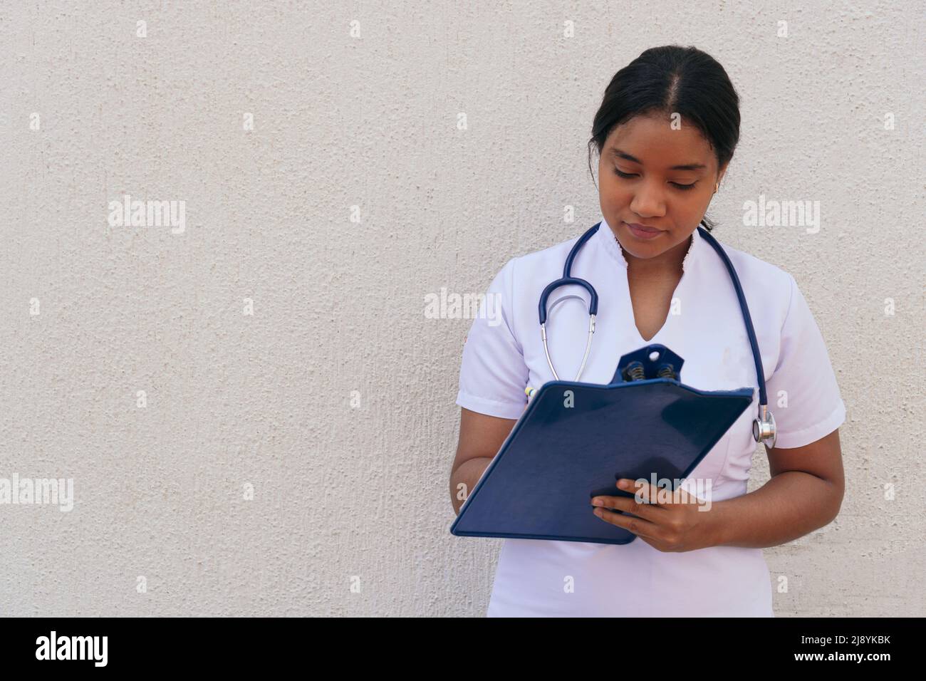 Ritratto di un giovane dottore di latina prendendo appunti Foto Stock