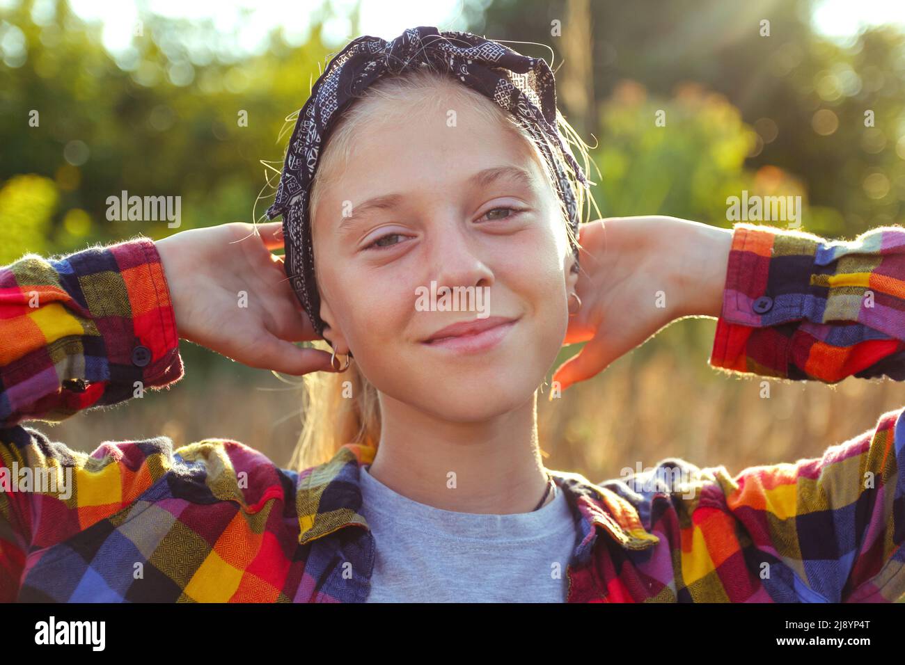 Defocus teen o ragazza di età preteen a piedi sulla natura sfondo. Bambina piccola che tiene mazzo di pampas erba. Prato verde. Generazione z. Autunno. Bandana. Foto Stock