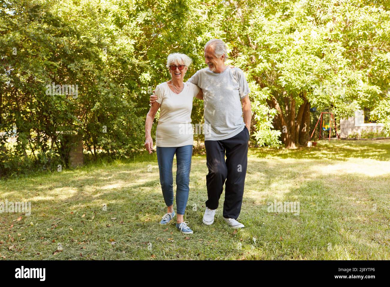 Felice pensionato senior coppia fare una passeggiata nella natura in estate Foto Stock